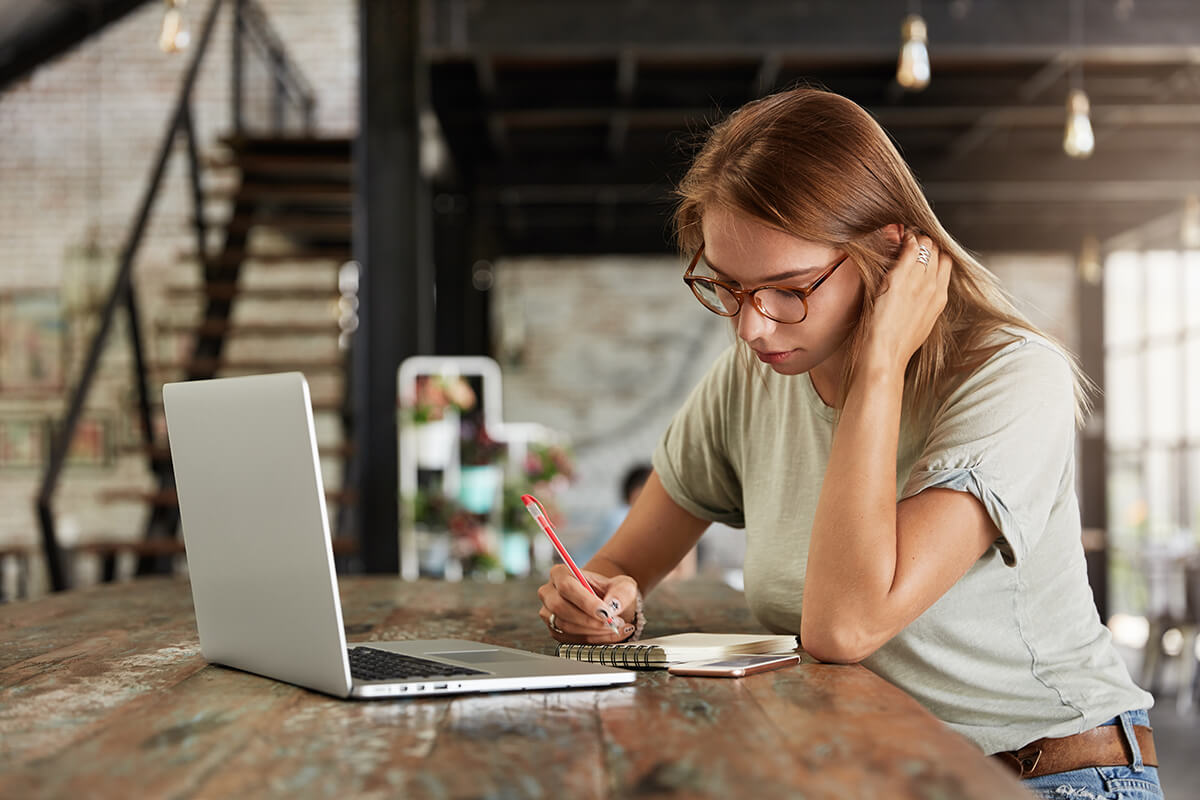 serious-female-student-concentrated-on-writing-28UG5RG.jpg